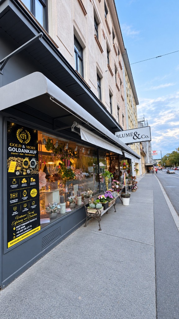 Außenansicht der Filiale Krottenbachstraße 52 mit Blume & Co. und Gold & More Schaufenster